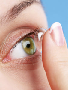 kvinde sætter kontaktlinse i øjet